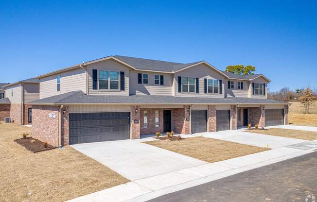 a house with two garages and a sidewalk in front of it