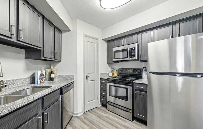 A kitchen with black cabinets and stainless steel appliances.