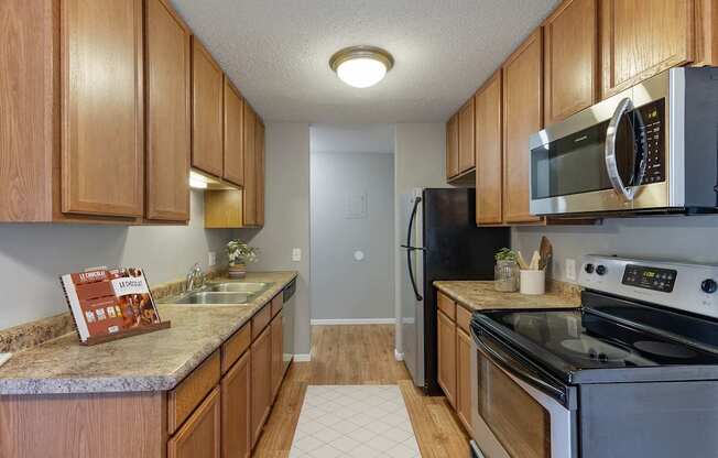 A kitchen with wooden cabinets and a granite counter top.