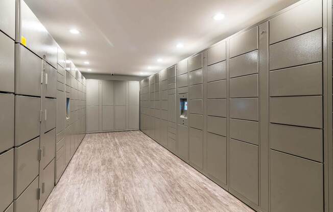 A long hallway with a series of lockers on the wall.