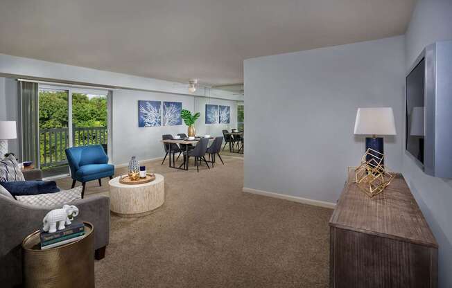 A living room with a grey couch, a blue chair, a wooden table, and a television.