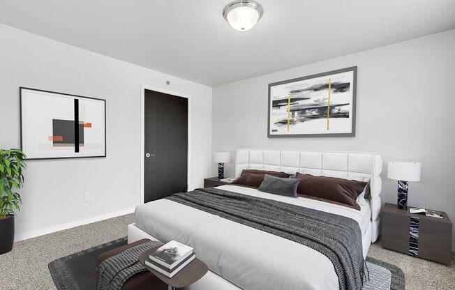 A bedroom with a large bed, a nightstand, and a painting on the wall.