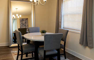 a dining room with a mirror, area rug, chandelier