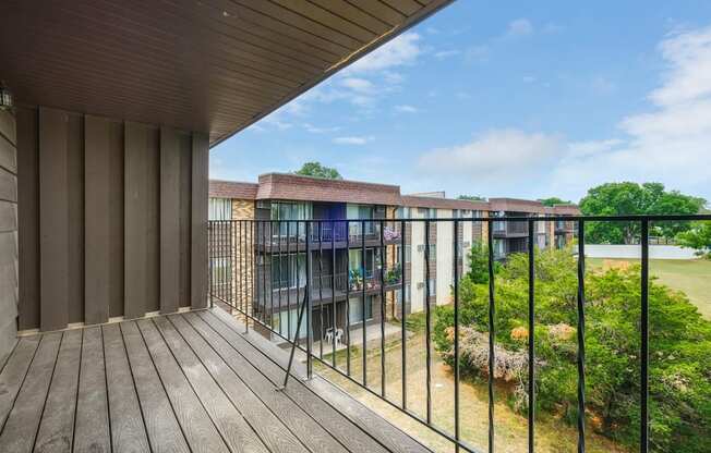 a balcony with a wooden floor and a metal railing