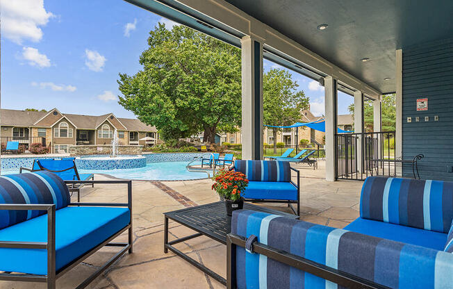 a balcony with blue chairs and a view of a yard and trees