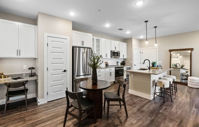 a kitchen and dining room with white cabinets and a table