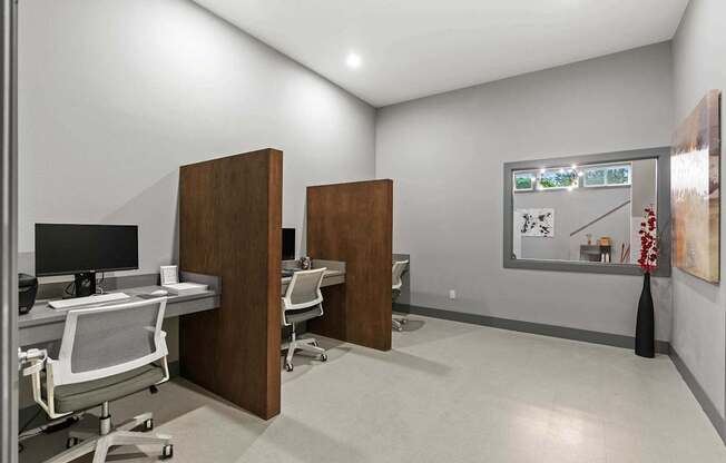 A room with a desk, chairs, and a painting on the wall. at Northpoint Apartments, Tacoma