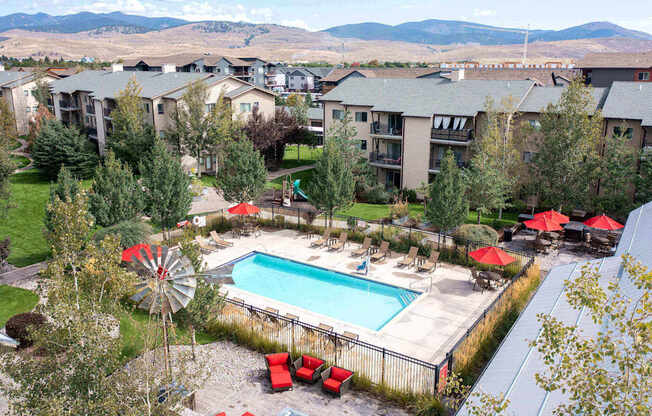 Aerial view of a pool with lounge chairs and umbrellas at Mullan Reserve Apartments, Missoula, MT, 59808