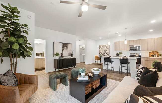 A living room with a brown couch, a coffee table, and a ceiling fan.