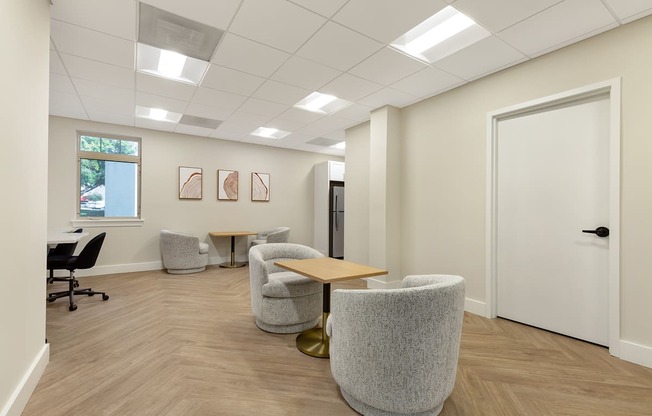 a waiting room with chairs and a table in front of a door at Copper and Quarry Village, Pikesville, 21209
