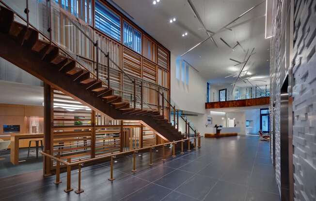 A wooden staircase with a metal railing leads to a second floor.