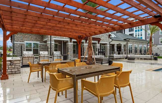 an outdoor patio with a pergola and tables and chairs