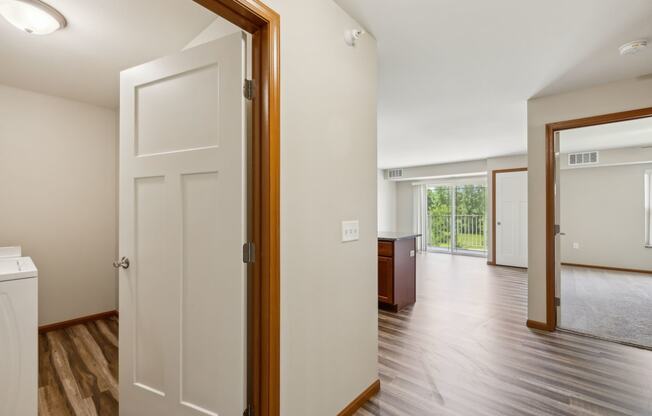 an open door leading into a living room and a kitchen