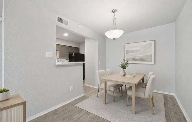 A dining room with a wooden table and chairs.