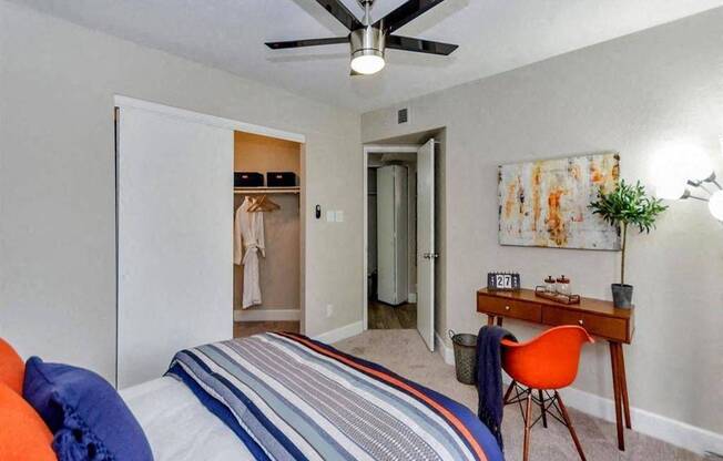 A bedroom with a bed, desk, and chair.