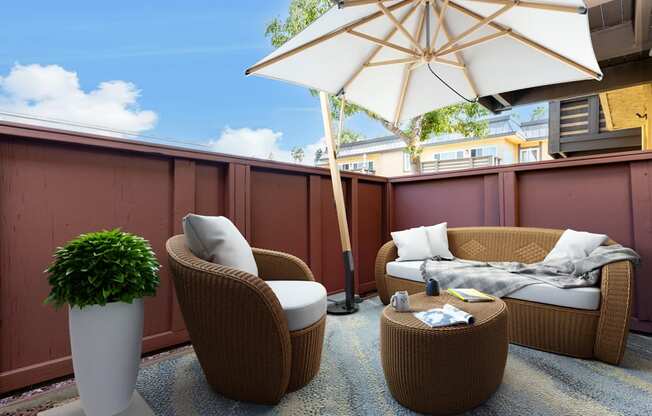 a patio with chairs and an umbrella on a balcony