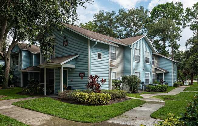 a blue house with a sidewalk in front of it