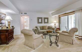 a living room with a couch and chairs and a table