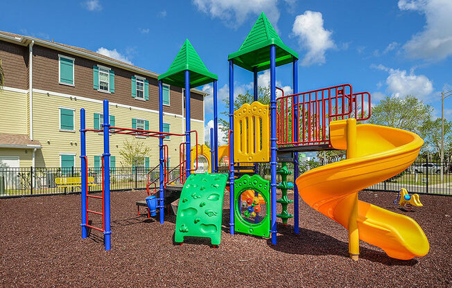 a playground with a slide and other toys in front of a building  at Cabana Club - Galleria Club, Jacksonville, Florida