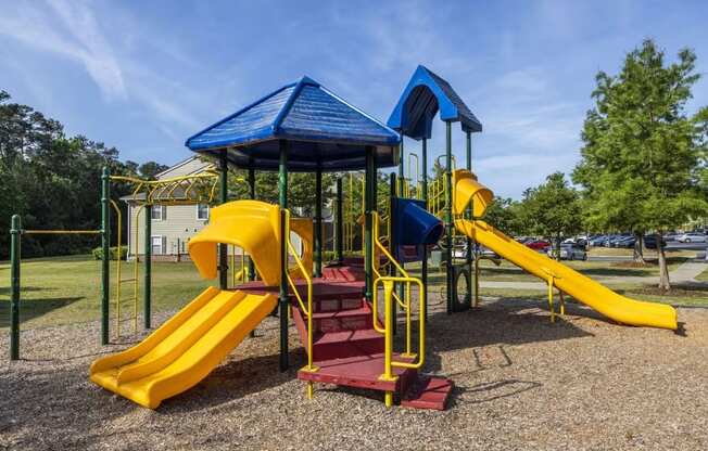 a playground with a yellow and blue slide and monkey bars
