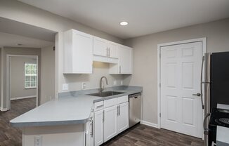 a kitchen with white cabinets and a sink and a refrigerator