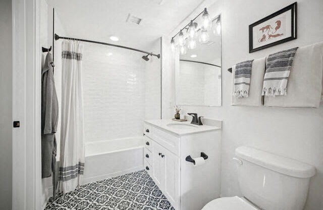 a white bathroom with a shower and a toilet