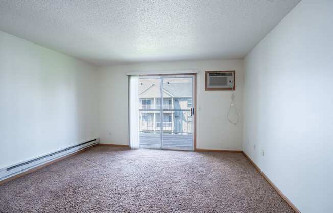 A room with a window and a door leading outside. Fargo, ND Stonebridge Apartments