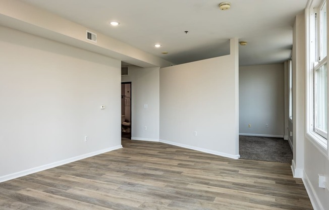 a living room with white walls and a wooden floor