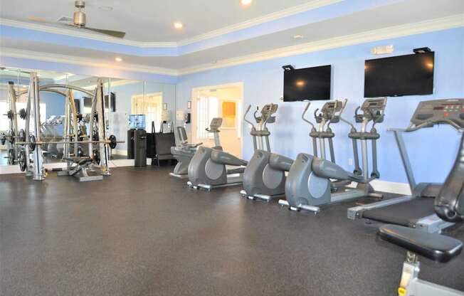 A gym with treadmills, weights, and exercise equipment.