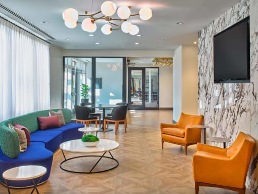 a lounge room with couches and chairs and a television at The Encore at Ingram Manor, Pikesville