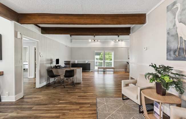 the living room and dining room of a home with wood floors and white walls