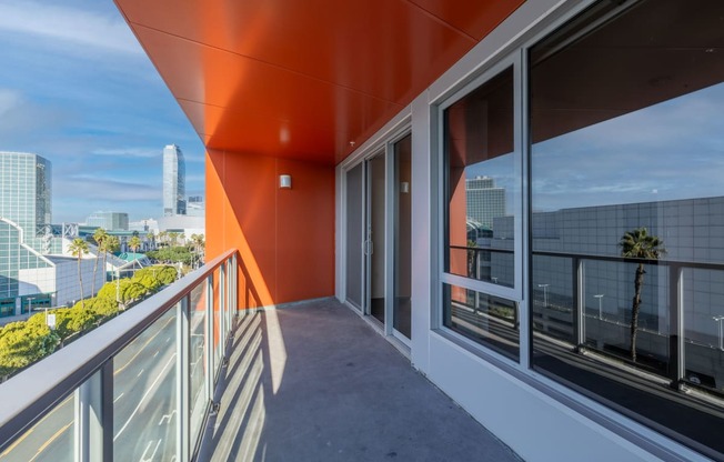 a balcony with a view of a city and a glass door