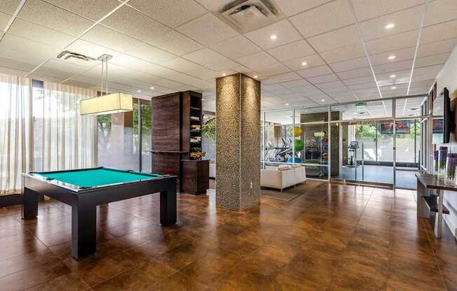 A room with a pool table and a bar.
