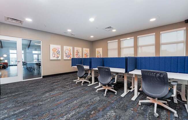 A conference room with blue chairs and a carpeted floor.