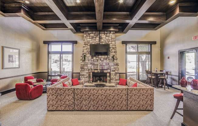 Large community clubhouse with a large couch overlooking a fireplace at Cypress Lake at Stonebriar in Frisco, TX!