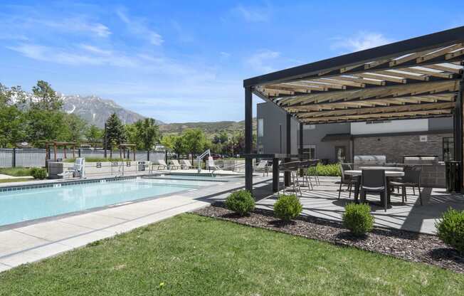 a backyard with a pool and patio with a pergola at The Flats at Riverwoods, Utah, 84604