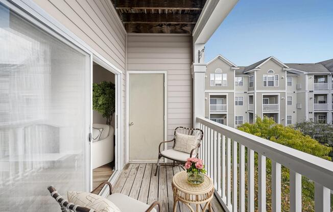 Private balcony with room for outdoor seating, offering a comfortable extension of the home and views of the surrounding community.
