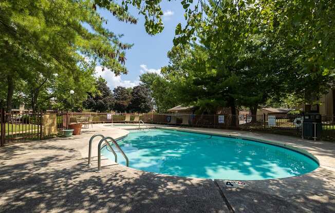 Multiple sparkling pools at Skyler Ridge Complex, surrounded by lounge chairs and lush greenery.