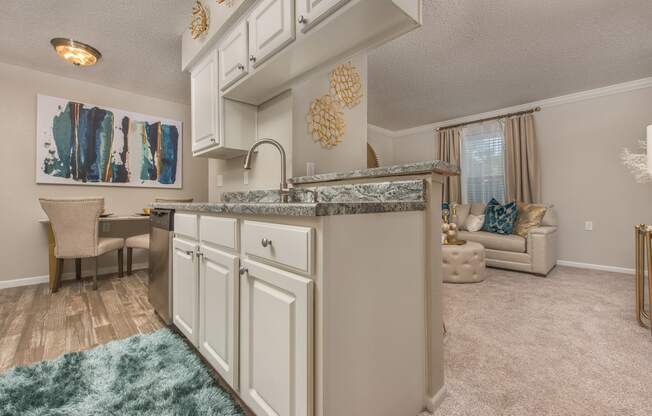 a kitchen with white cabinets and a living room with a couch at Highland Ridge Apartments, Overland Park , KS 66210