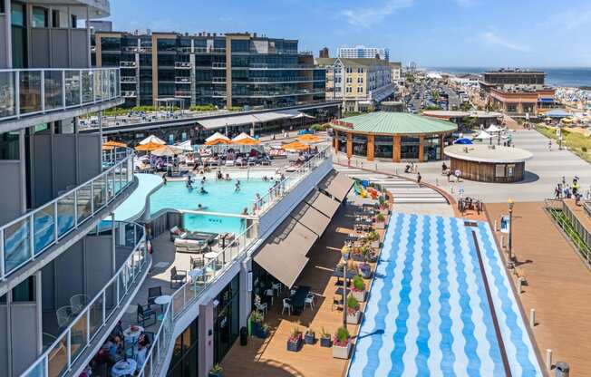 A large outdoor pool area with people enjoying the sunny day.