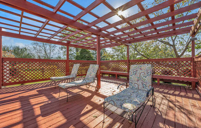 A wooden deck with two chairs and a table.