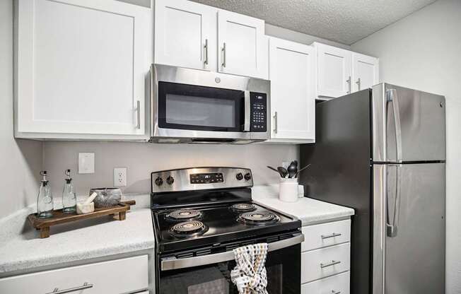 A modern kitchen with white cabinets and stainless steel appliances.