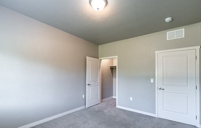 a bedroom with two doors and a closet