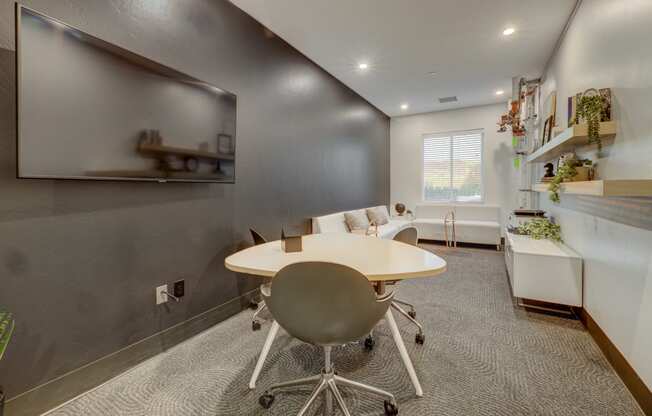 conference room with white table and chairs and a tv on the wall