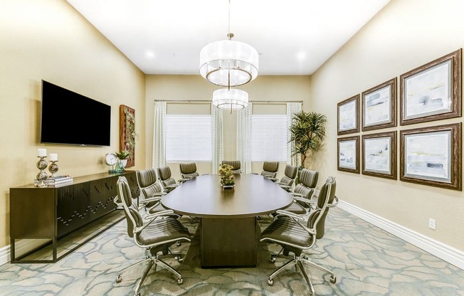 A conference room with a large table surrounded by chairs.