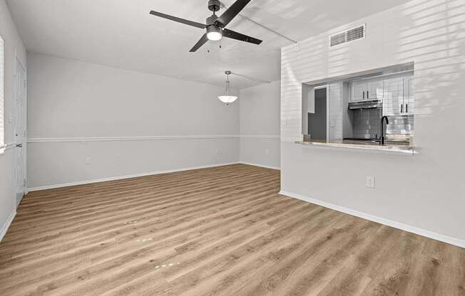 A room with a ceiling fan and wooden flooring.