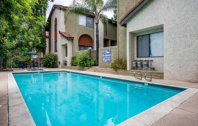 A swimming pool with a building in the background in