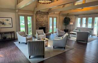 A living room with a stone fireplace and striped armchairs.