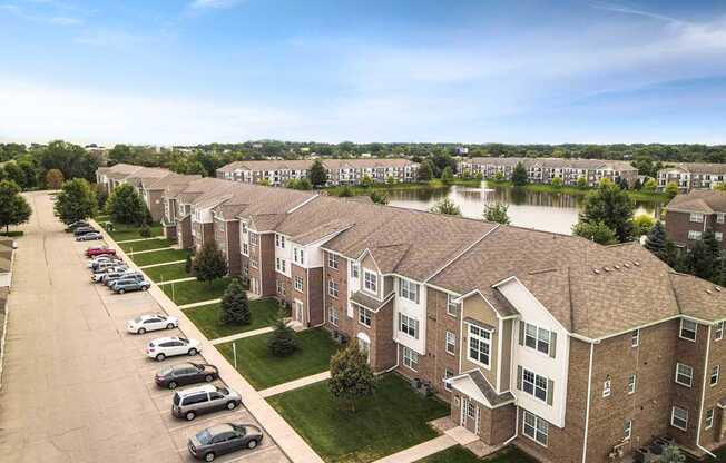 A row of houses with a parking lot in front.