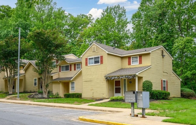 A yellow house with a mailbox in front.